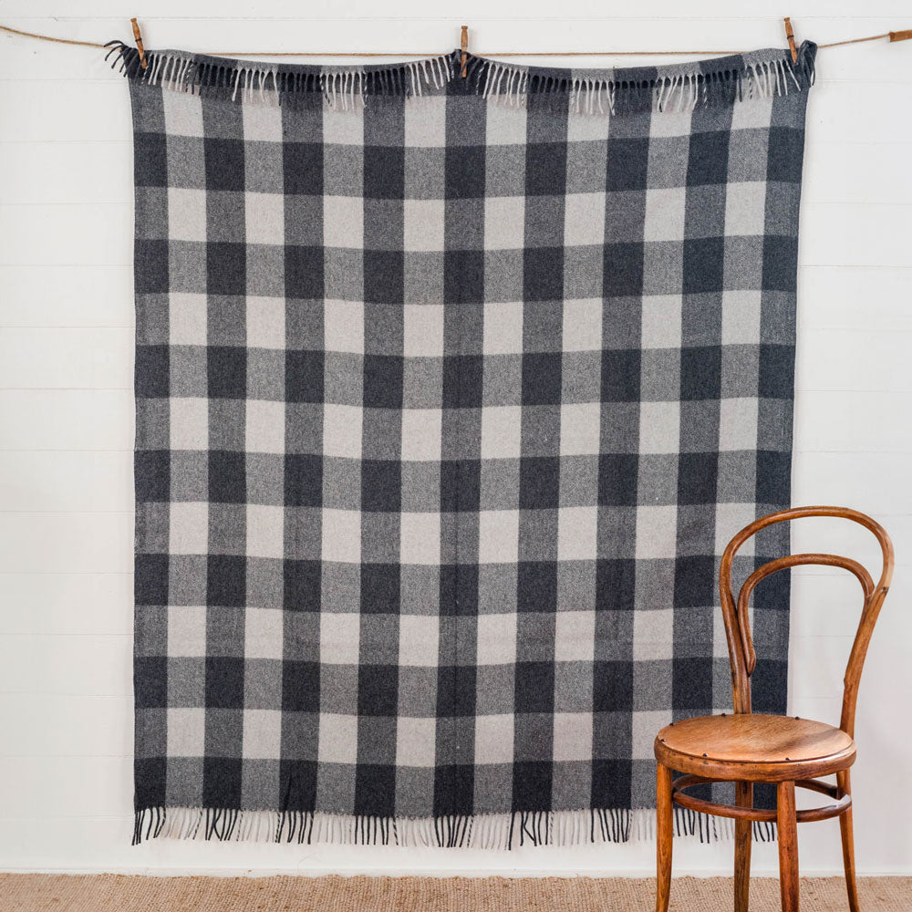 Grey and charcoal tartan blanket hung up to see the pattern of the whole blanket. 