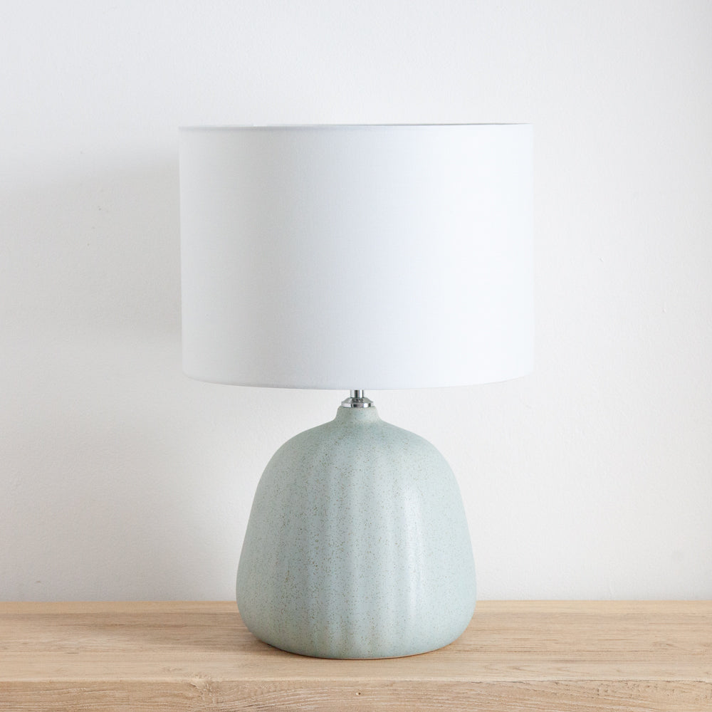 Table lamp with blue ceramic base and white shade.