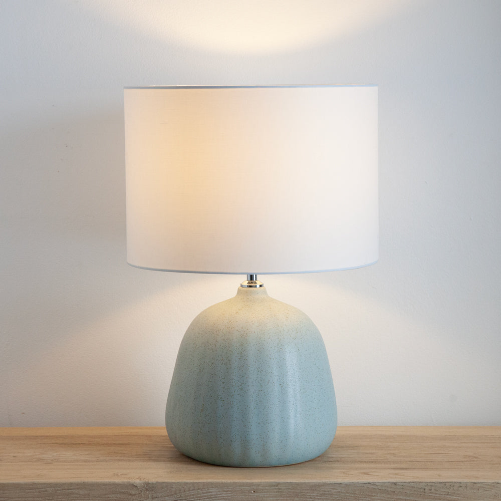 Table lamp with blue ceramic base and white shade.