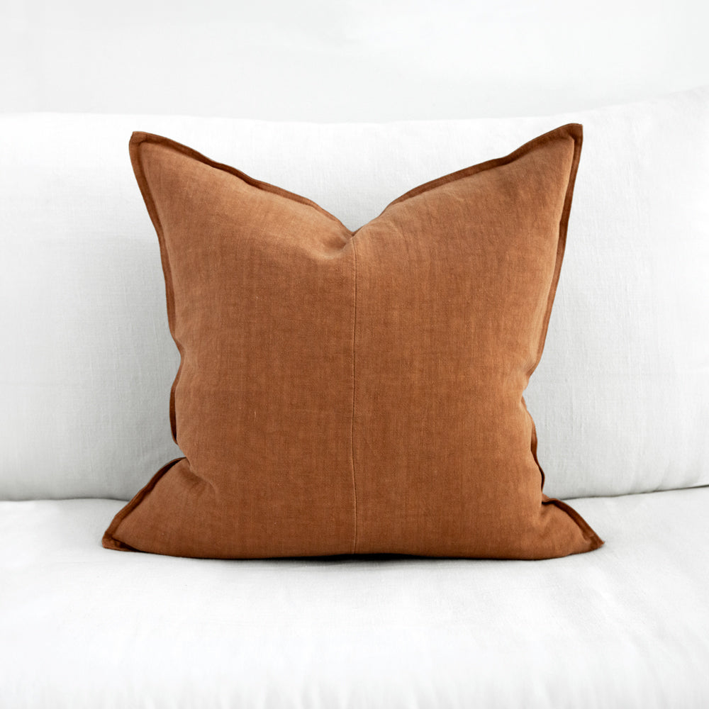 Square amber coloured linen cushion.