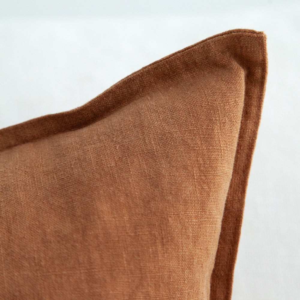 Square amber coloured linen cushion.