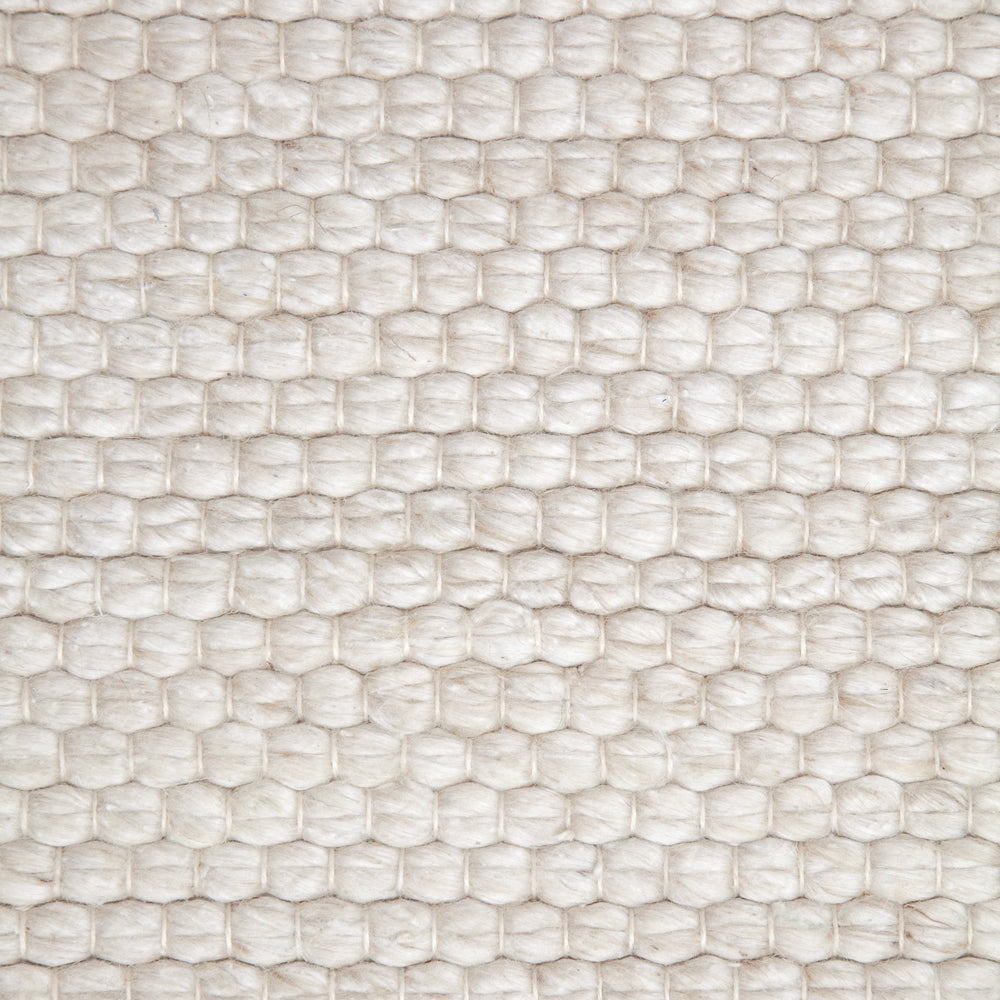 Close up light coloured indoor outdoor rug.
