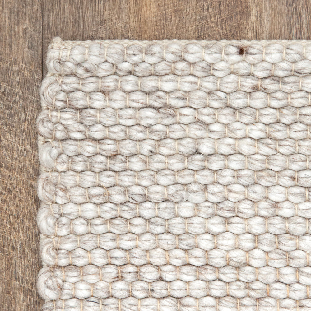 Close up of light coloured indoor outdoor rug with warm tone. 
