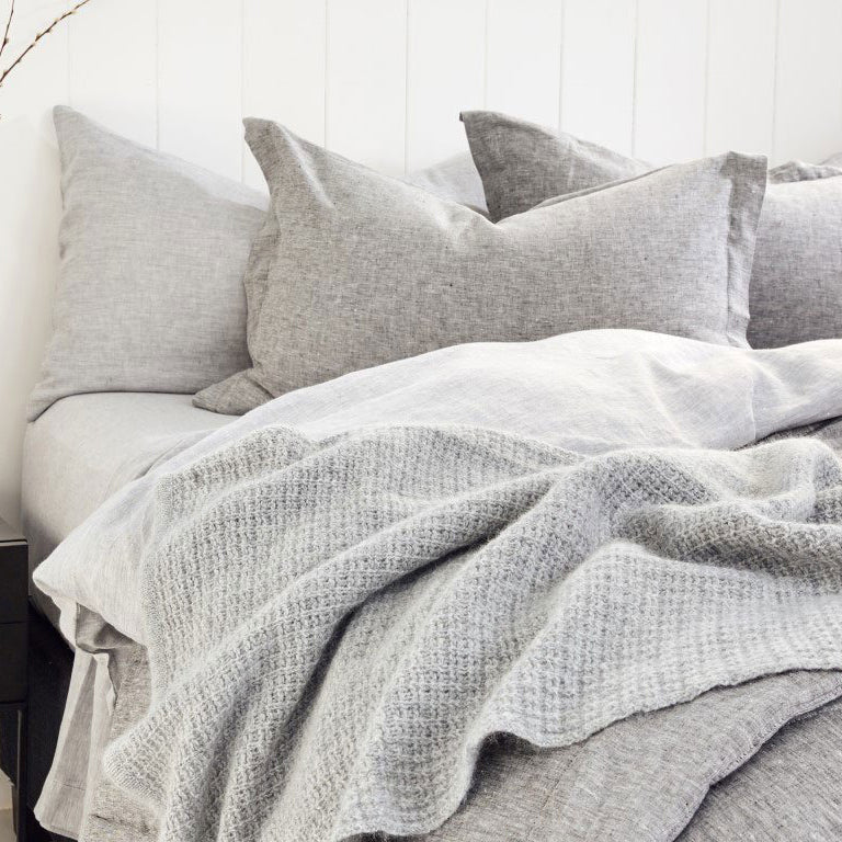 Bebmoka chunky box knit angora merino wool throw on grey bedding.