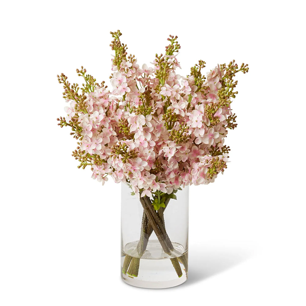 Pink artificial flowers in glass vase.