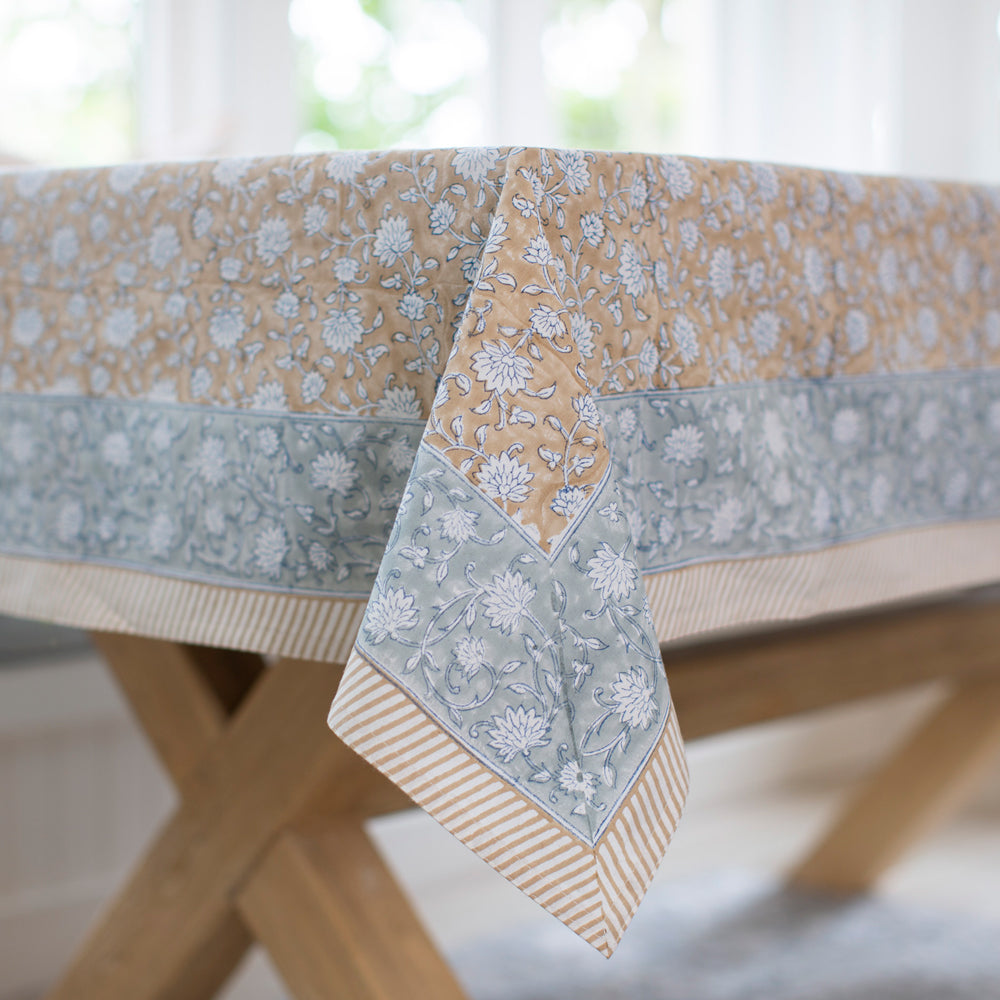 Block printed tablecloth with floral motif and blue border.