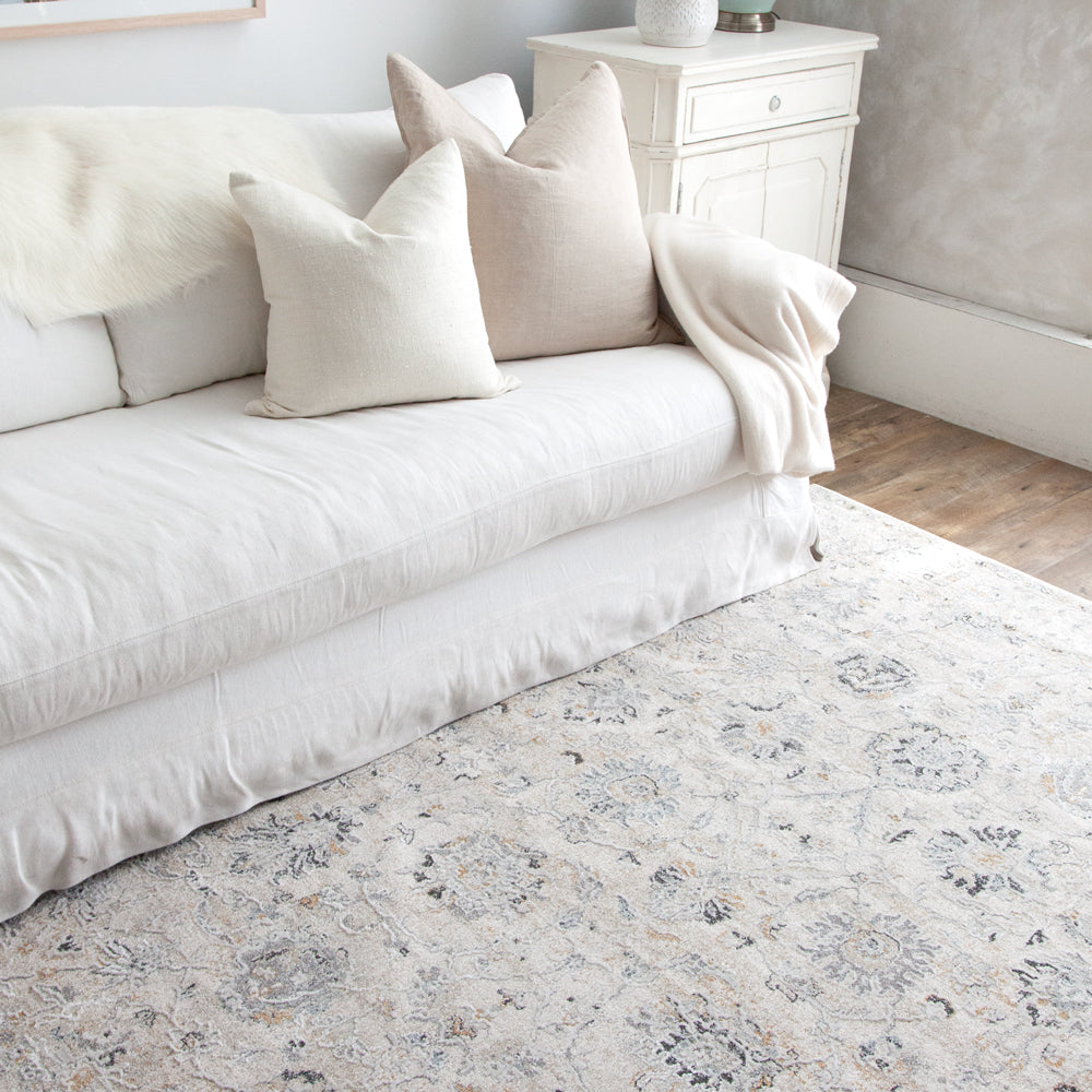 Turkish style rug in off white and blue colours paired with white sofa. 