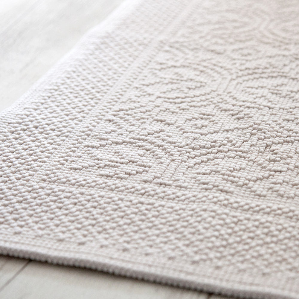 Textured bath mat in off white colour.