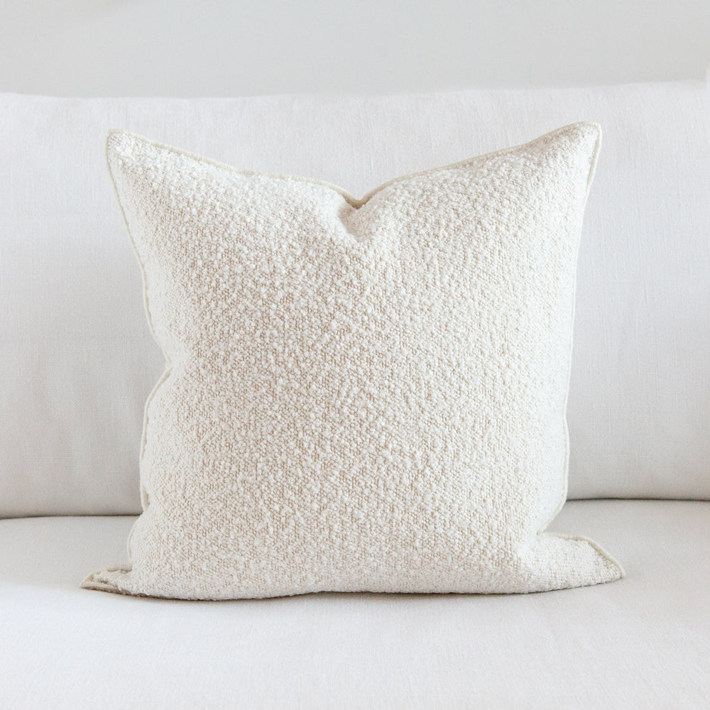 Light cream boucle textured square cushion.