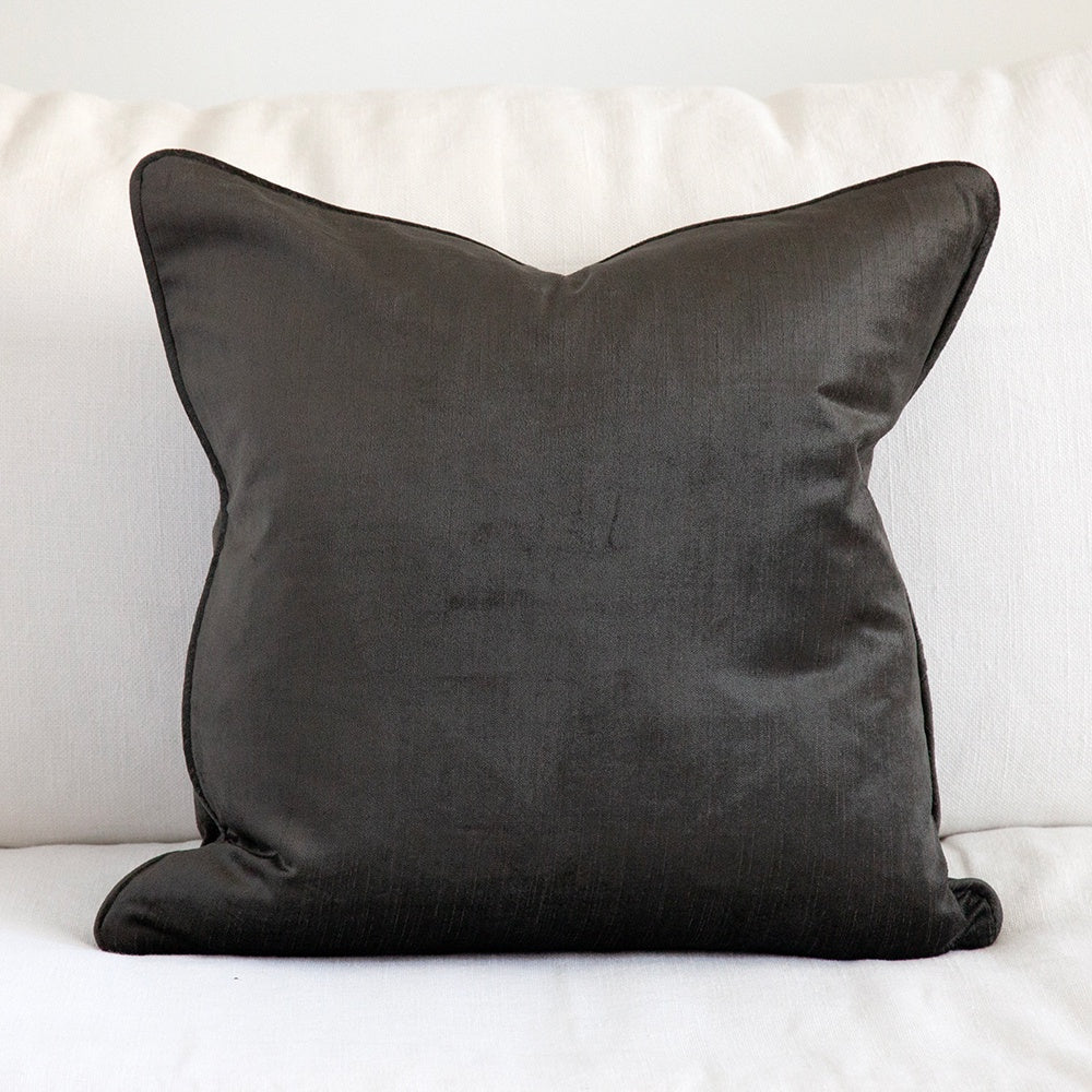 Graphite velvet cushion on white sofa.