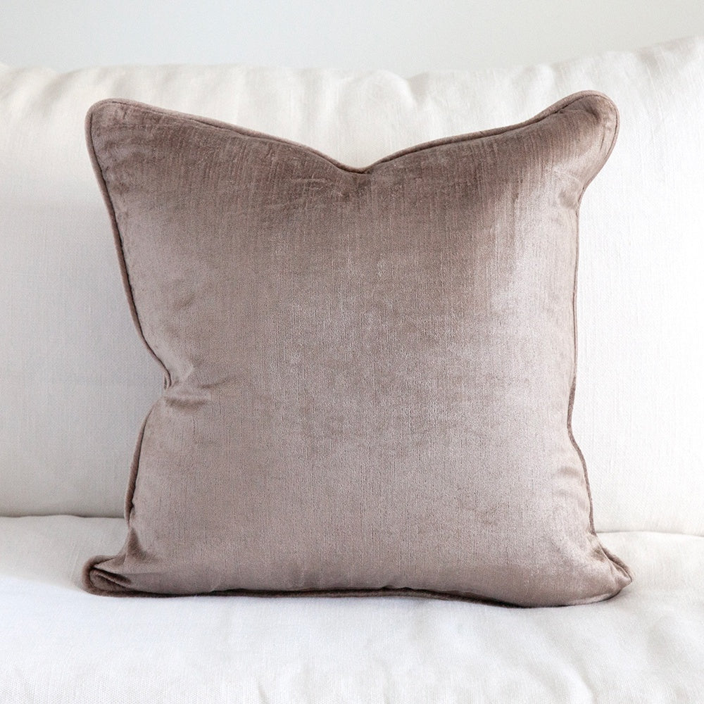 Mauve velvet cushion on white sofa.