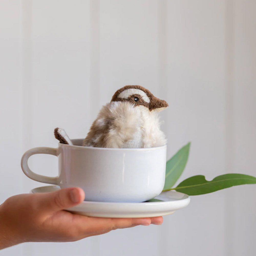 Plush kookaburra baby rattle toy in tea cup.
