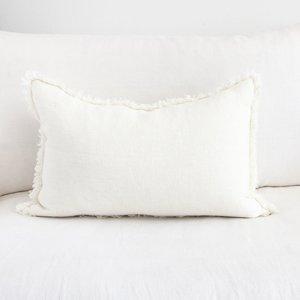 Frayed linen cushion in white.