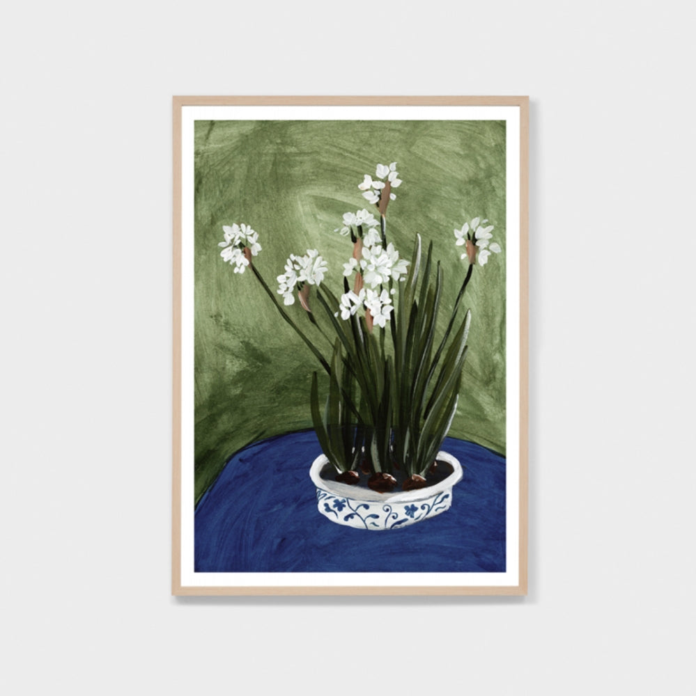 Framed wall art print featuring a painting of flowers in a shallow white and blue vase set against a blue and green background.