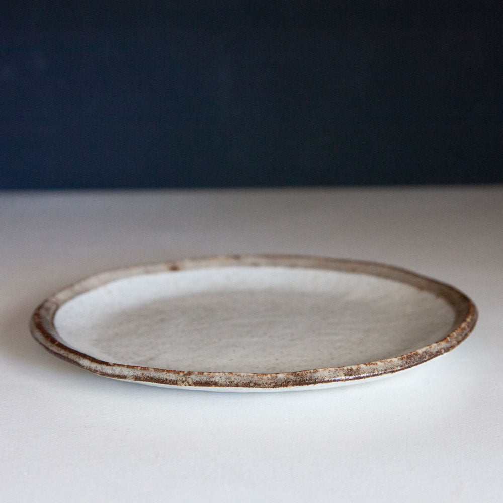 Small ceramic plate with brown rim.