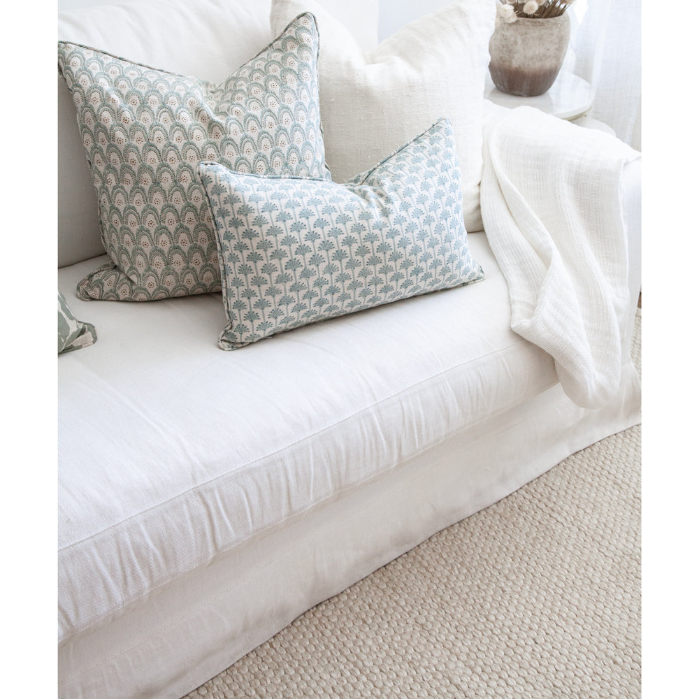 Light coloured rug with white sofa and celadon cushions.