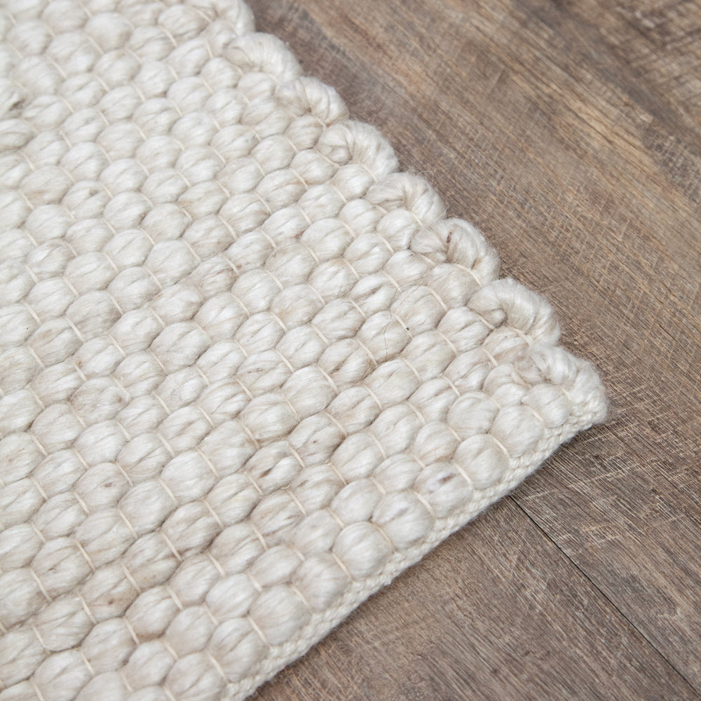 Close up light coloured indoor outdoor rug.