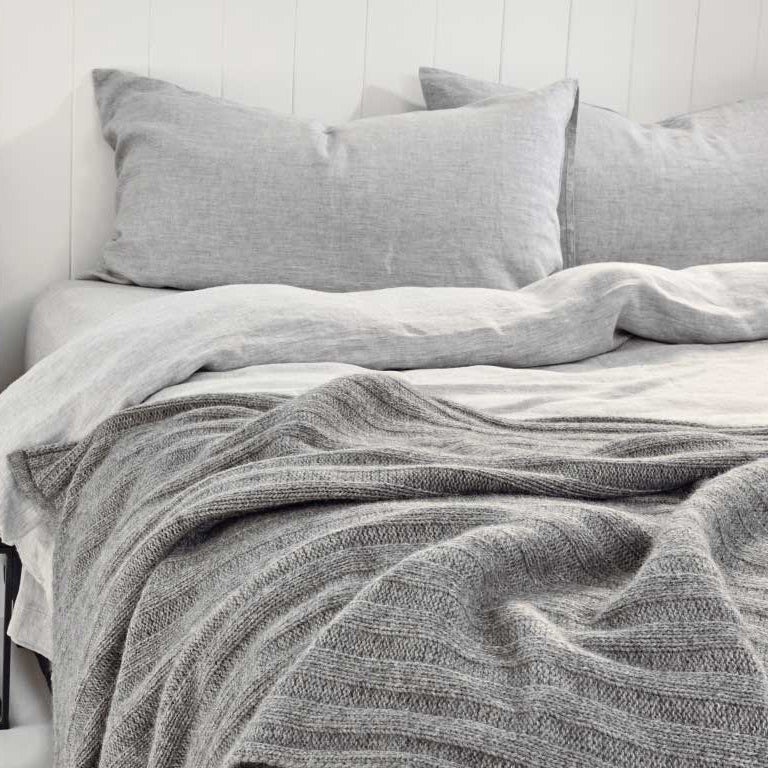 Bemboka angora merino throw in dove grey on bed.