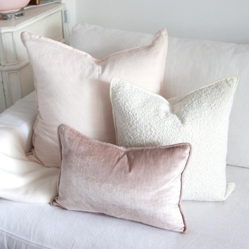 Pink cushion collection on white sofa.