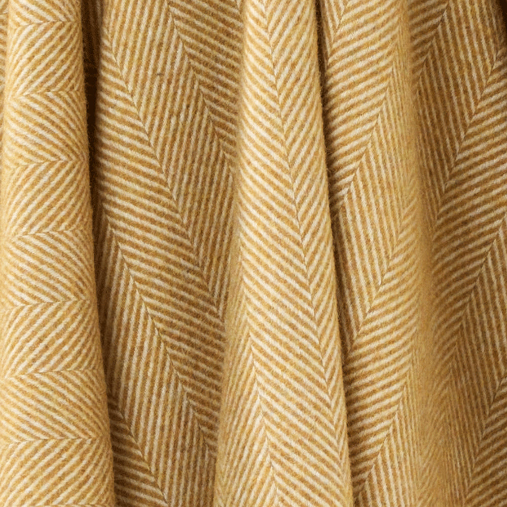 Close up of Bronte by Moon mustard yellow herringbone throw.