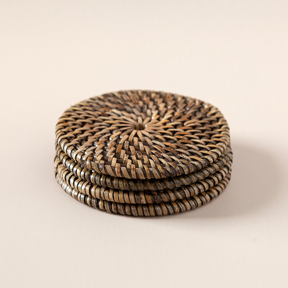 Stack of four brown rattan coasters.