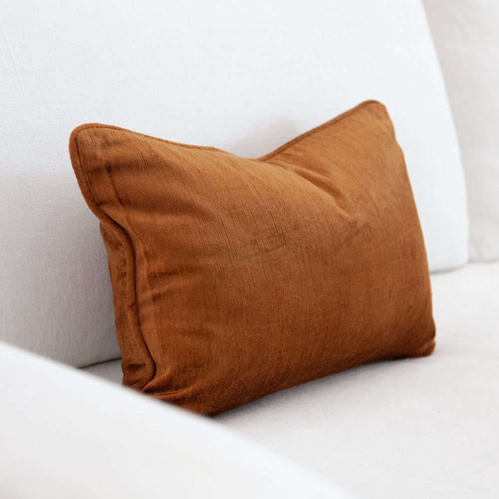 Small ochre coloured velvet cushion.