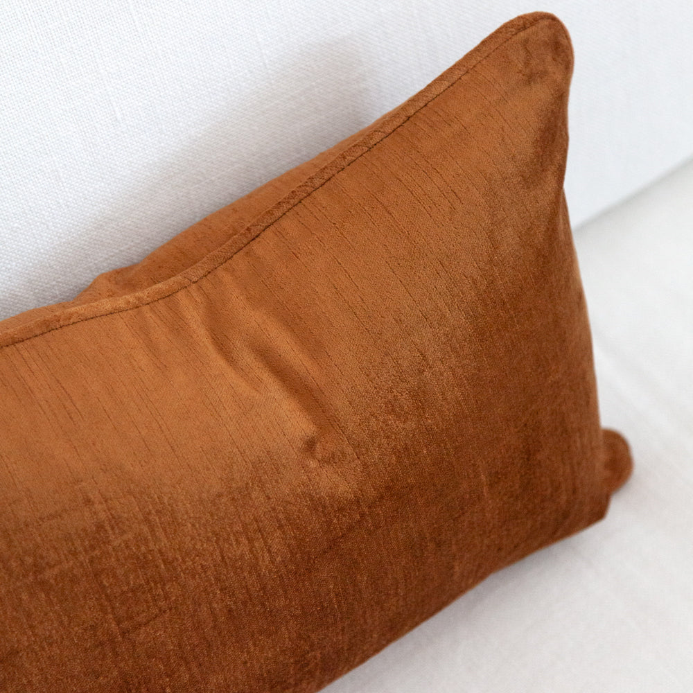 Close up of small ochre coloured velvet cushion.