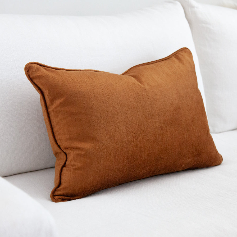 Ochre coloured rectangular velvet cushion.