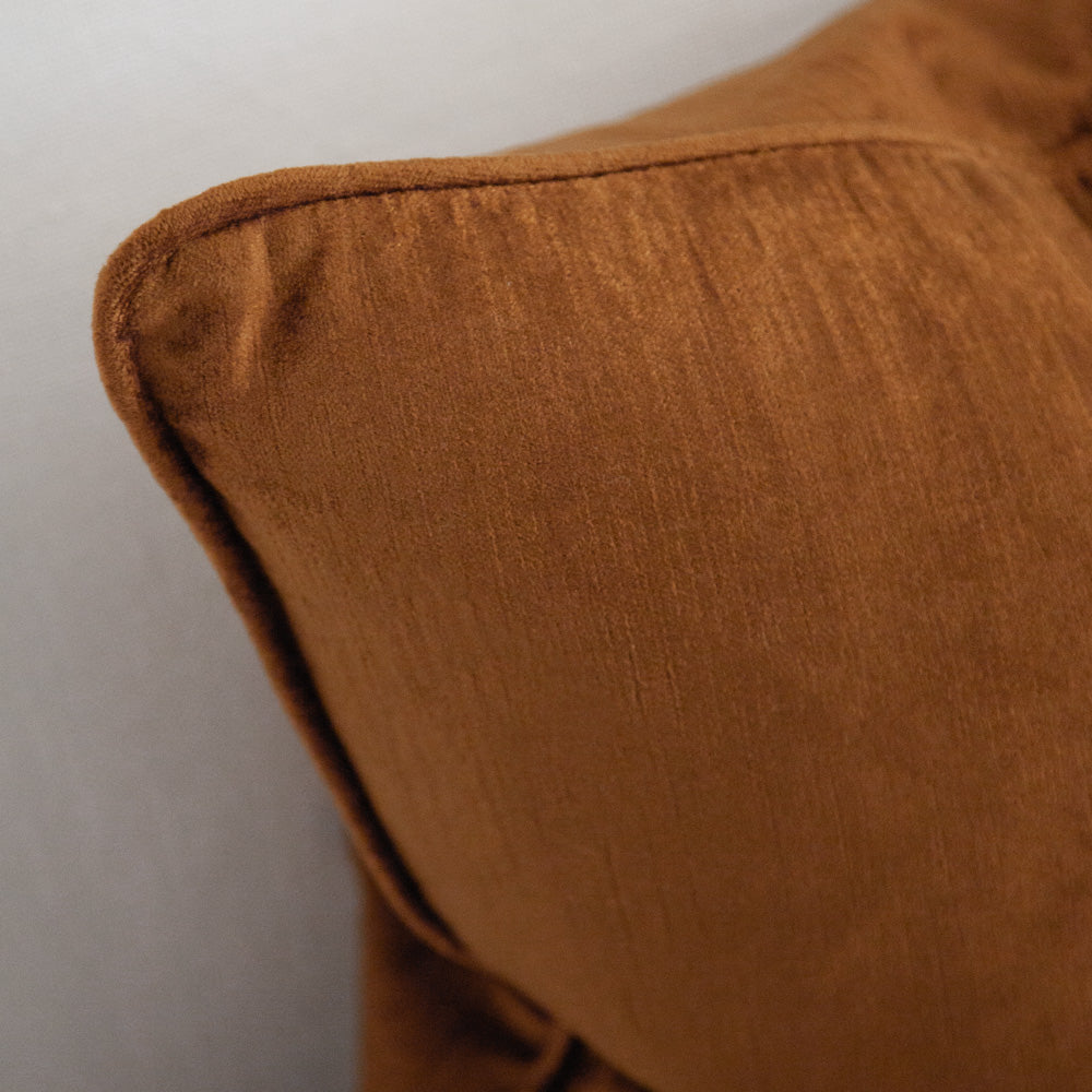 Ochre coloured square velvet cushion with piping.