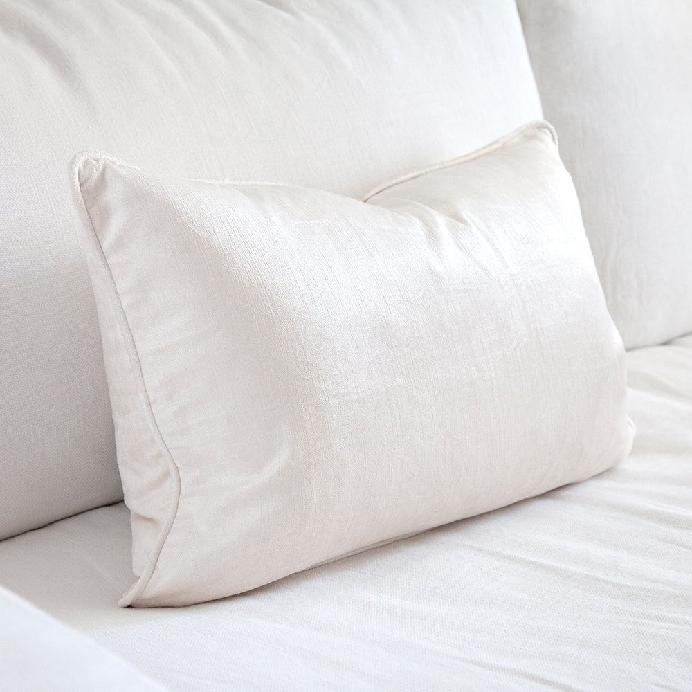 Ivory velvet cushion on white sofa.