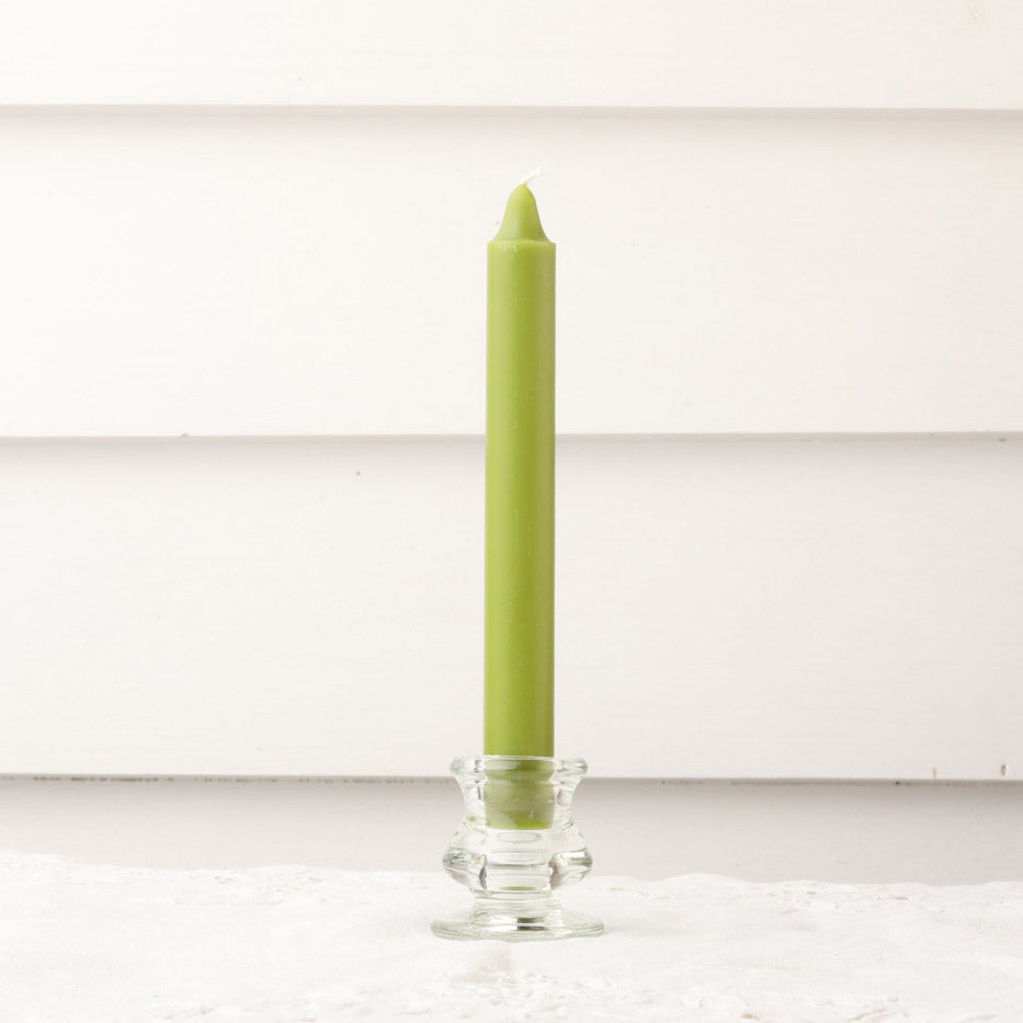 Green dinner candle in clear glass candle holder.