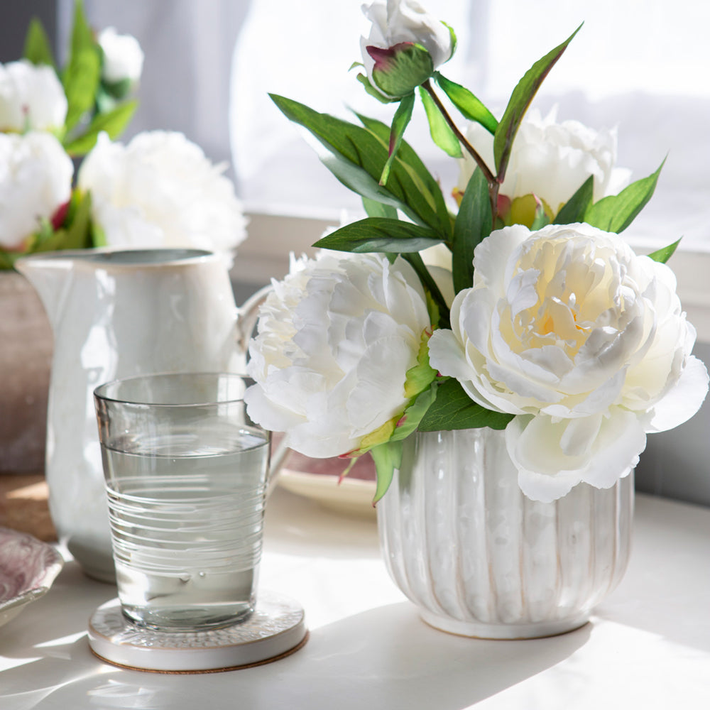 White ceramic planter being used as a vase.