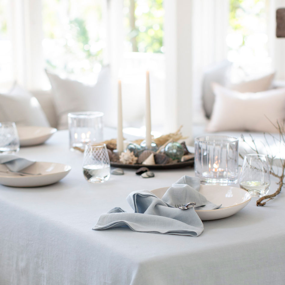 Light blue linen napkins styled on table setting with matching tablecloth.