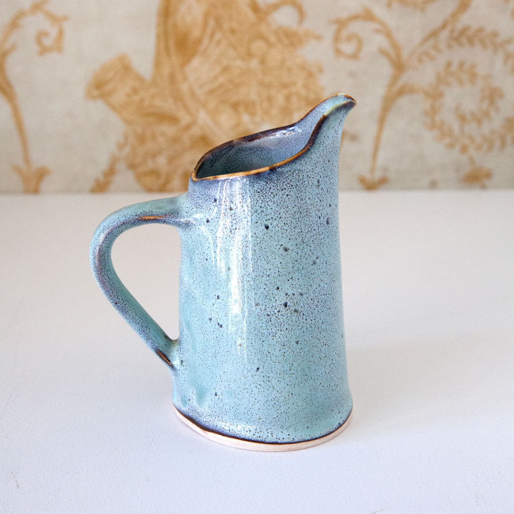 Small ceramic jug with blue/turquoise glaze.