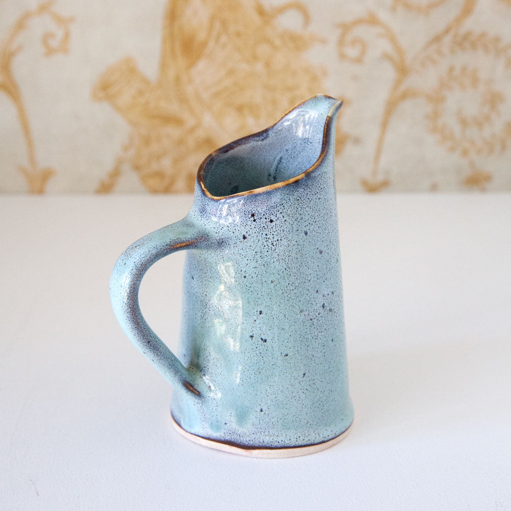 Small ceramic jug with blue/turquoise glaze.