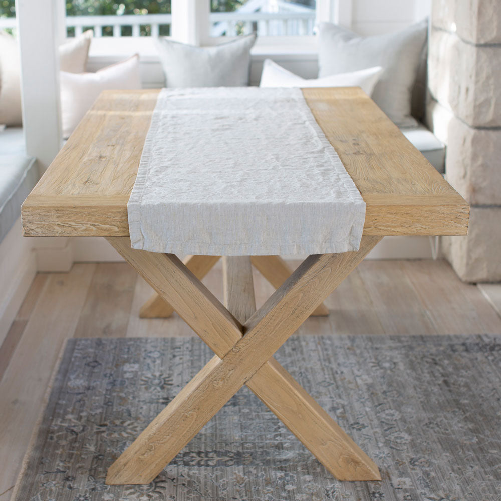 Natural linen table runner on a wooden table.