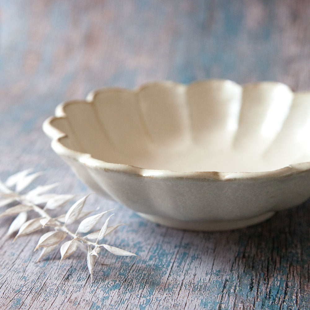 Rinka ceramic bowl featuring scalloped edged design resembling a flower.