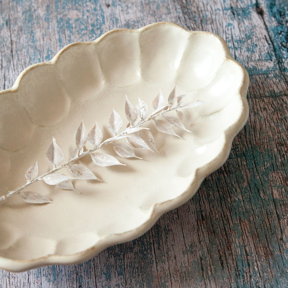 Rinka oval ceramic bowl featuring scalloped edged design resembling a flower.