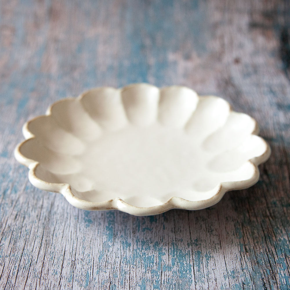 Rinka ceramic plate featuring scalloped edged design resembling a flower.