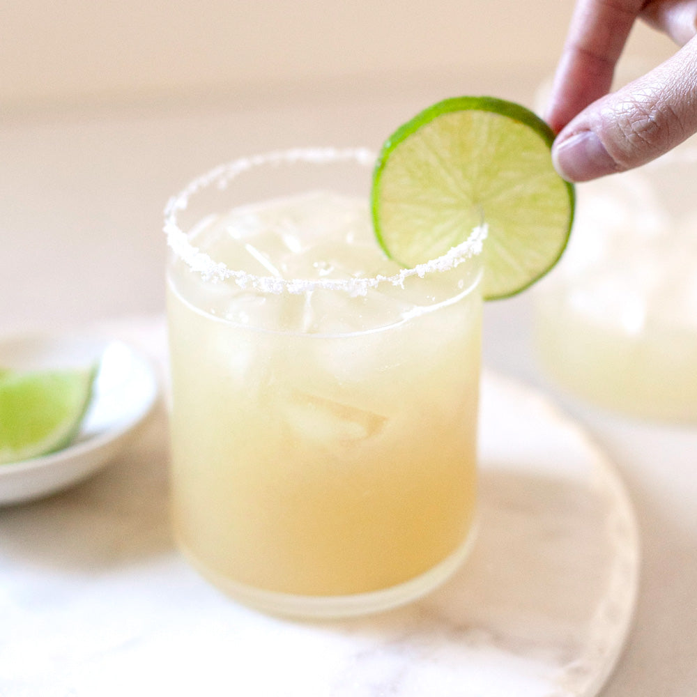 Clear modern glass tumbler with margarita.