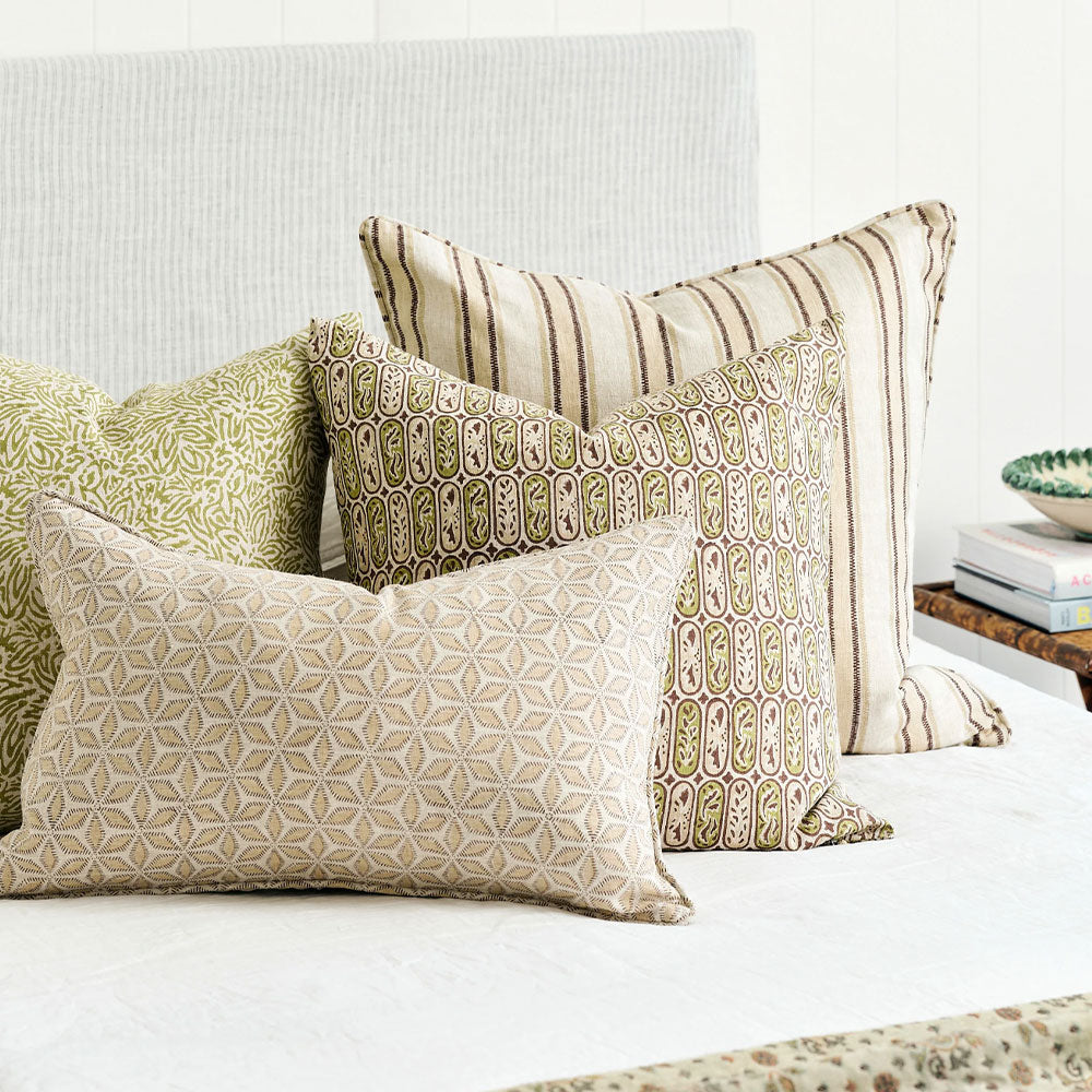 Walter G Hanami Shell Cushion on bed with other Walter G cushions.