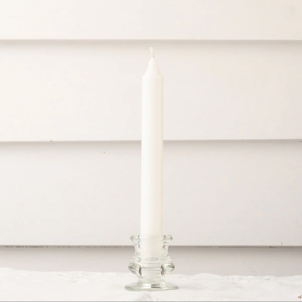 White dinner candle in clear glass candle holder