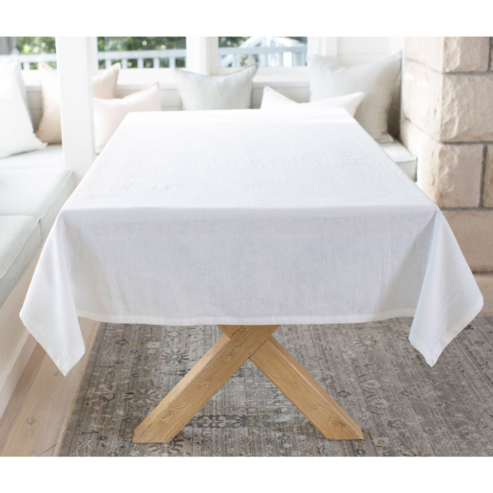 White linen tablecloth draped over a wooden table.