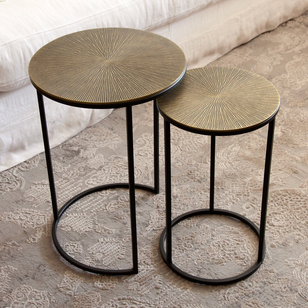 Round nesting side tables. Made from Aluminium with antique brass coloured tops and black legs.