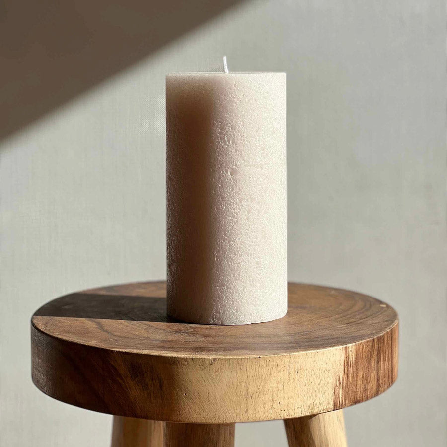 Textured pillar candle in soft beige colour.