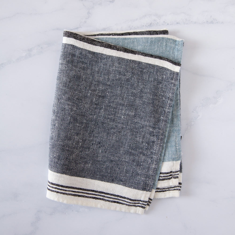 Blue banded tea towel on marble counter top.