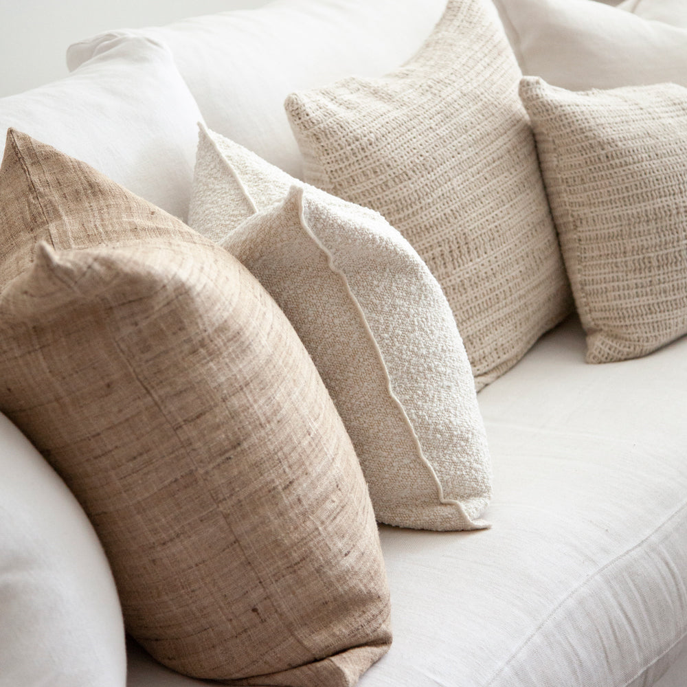 Textural cushions on sofa in neutral tones.