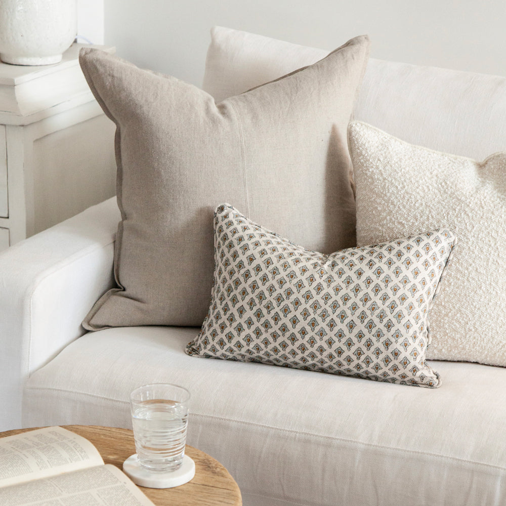 Cushions on sofa including cream boucle cushion.