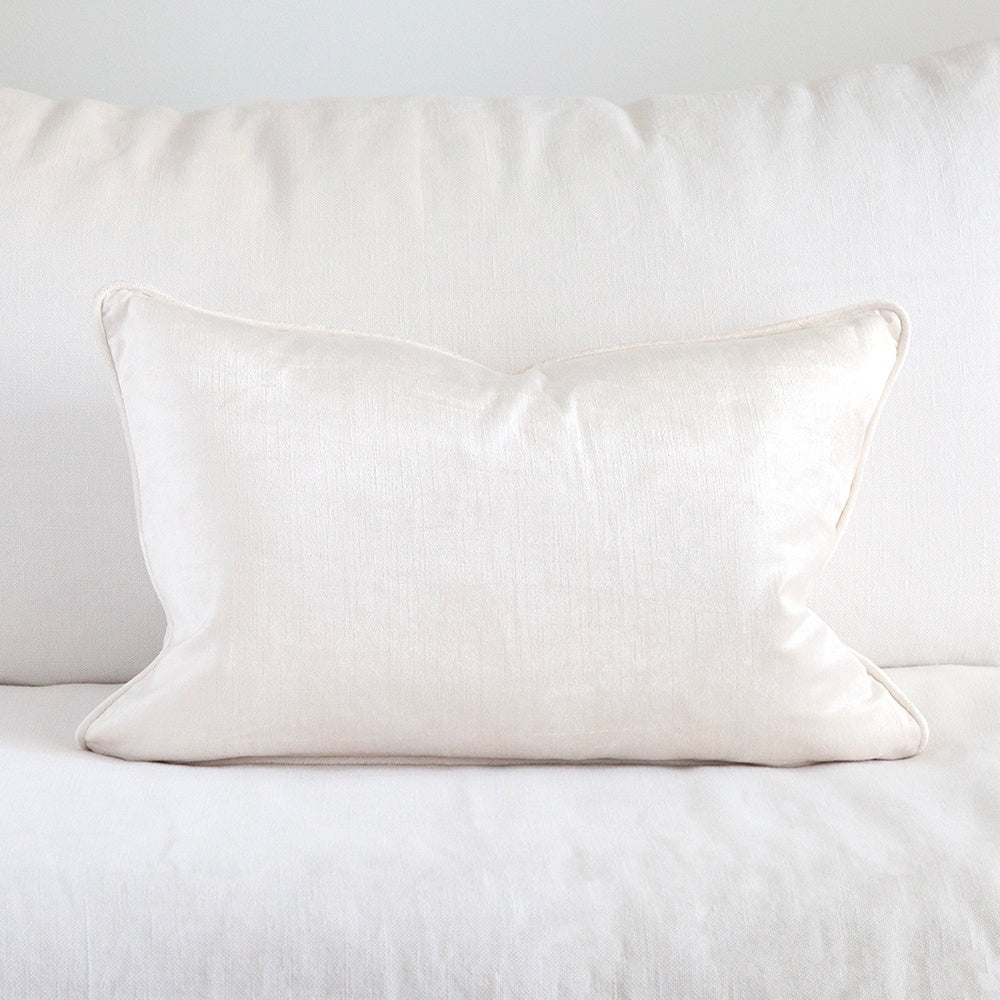 Ivory velvet cushion on white sofa.