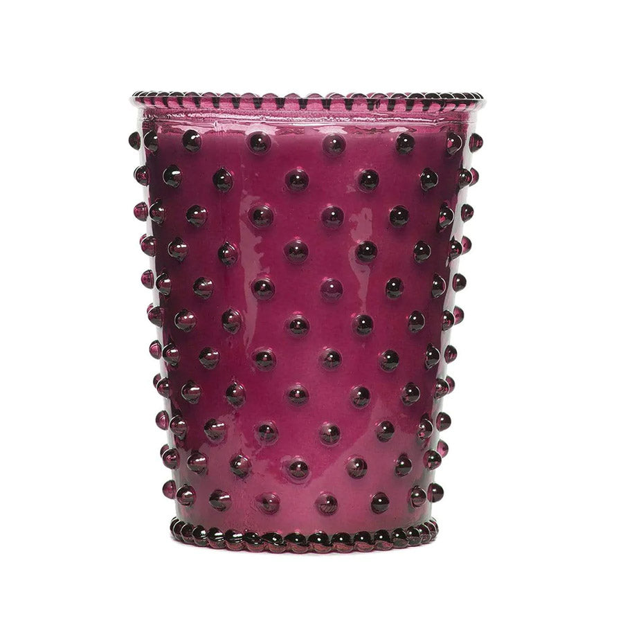 Purple glass candle with hobnail texture.